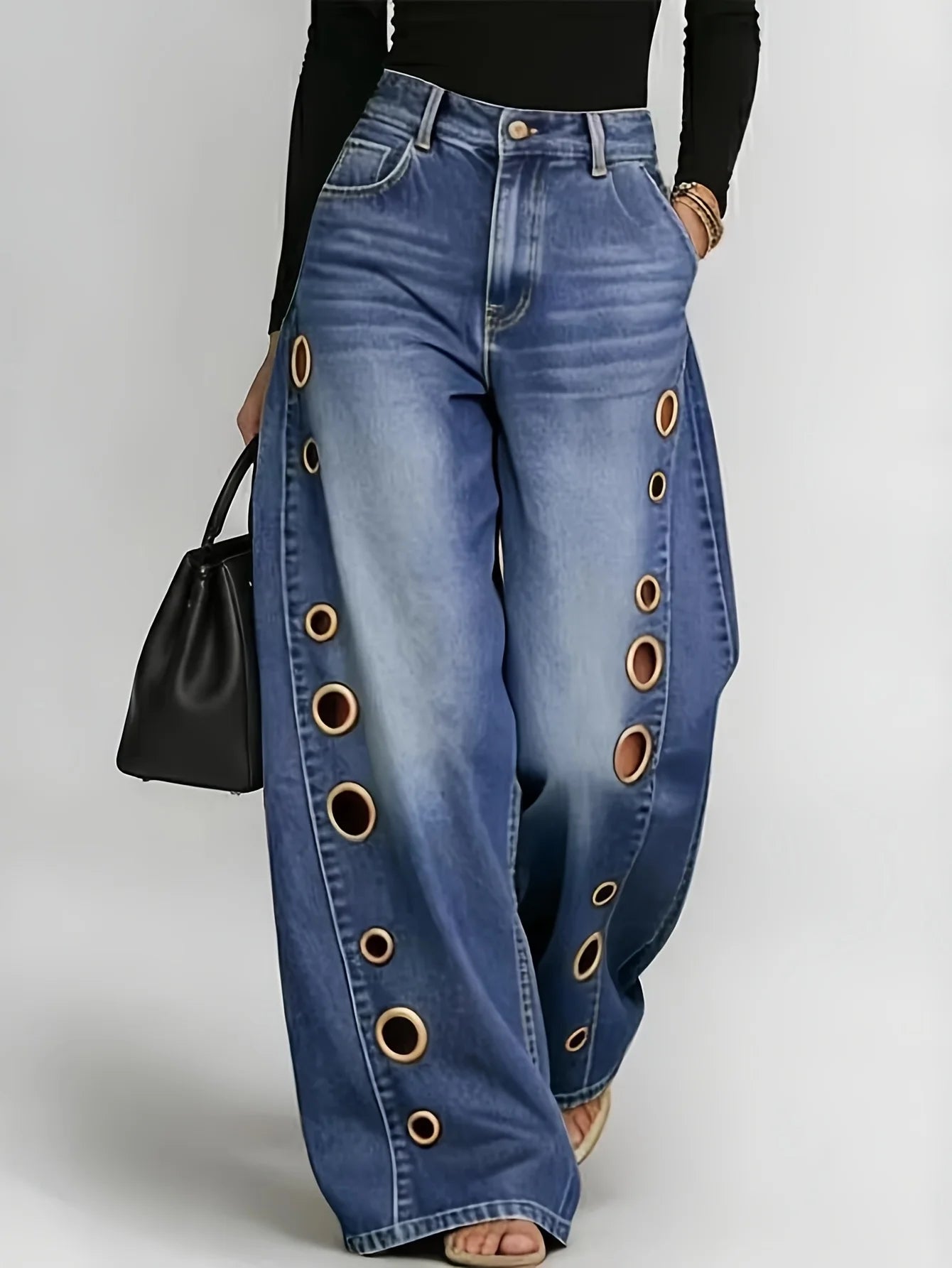 Retro-style wide-leg jeans with metallic eyelets, high-waisted, loose, floor-length fit, gradient eyelets of varying sizes on both sides, distressed washed finish, classic front and back pockets, perfect for everyday casual w